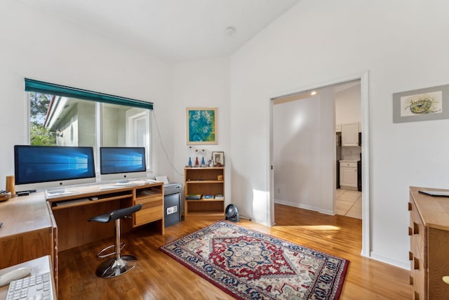 home office with baseboards and wood finished floors