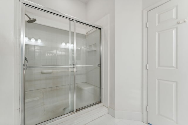 bathroom with a stall shower and baseboards