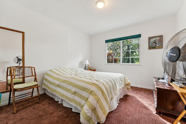 bedroom with baseboards and dark carpet