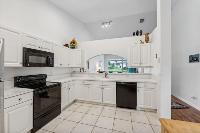 kitchen with black appliances, light countertops, and white cabinets