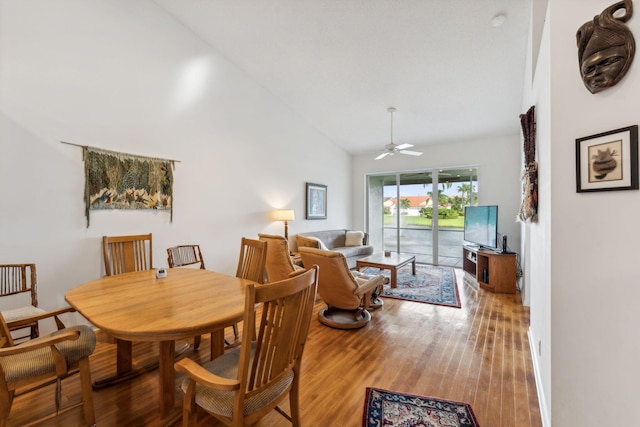 dining area with high vaulted ceiling, a ceiling fan, and wood finished floors