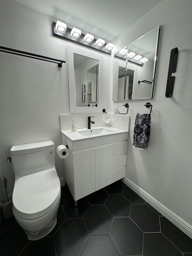 bathroom with vanity, toilet, and tile patterned floors