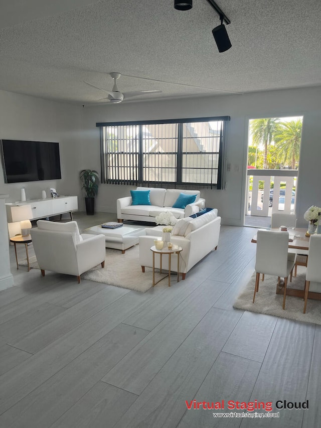 living room featuring a textured ceiling, a healthy amount of sunlight, and ceiling fan