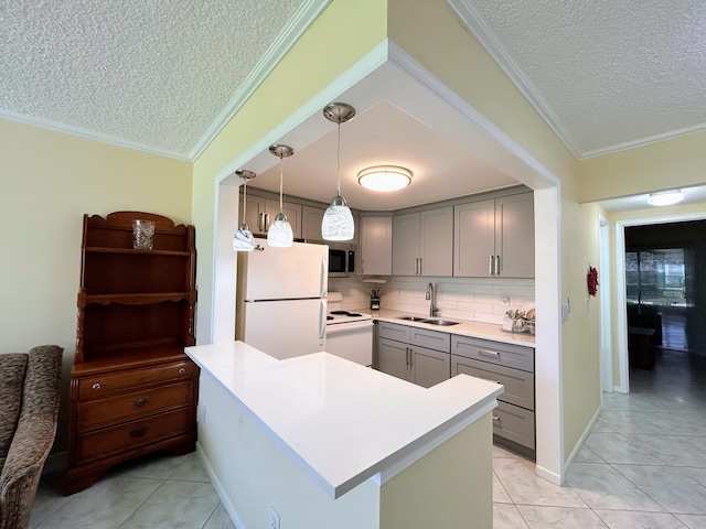 kitchen with white appliances, sink, a textured ceiling, kitchen peninsula, and decorative light fixtures