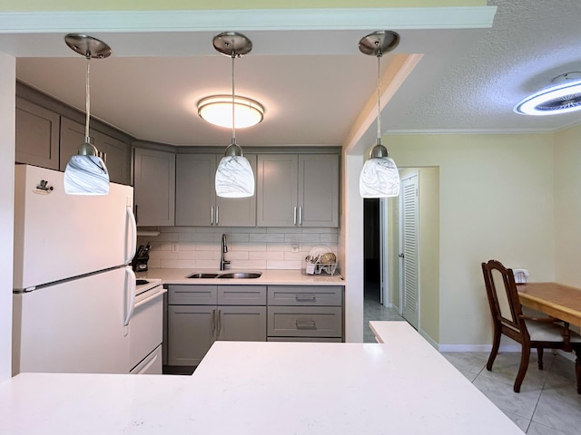 kitchen featuring decorative backsplash, gray cabinetry, sink, pendant lighting, and white appliances