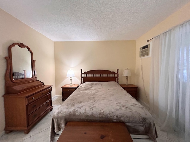 tiled bedroom featuring a wall mounted AC and a textured ceiling