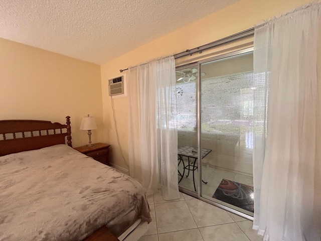 bedroom with a wall mounted AC, a textured ceiling, and light tile patterned floors