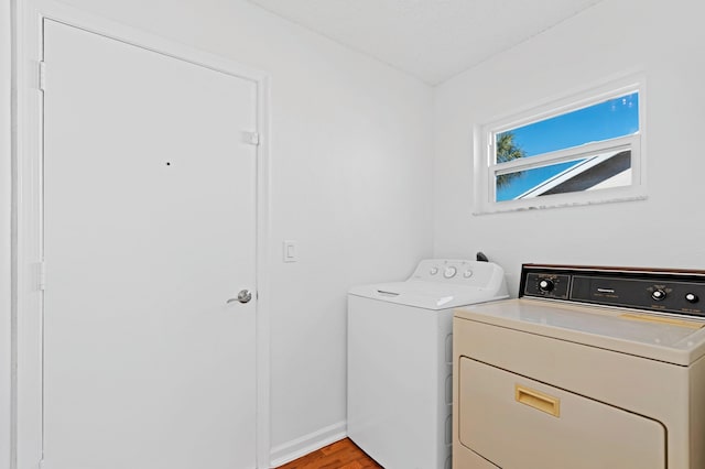 laundry area featuring washing machine and clothes dryer and light wood-type flooring