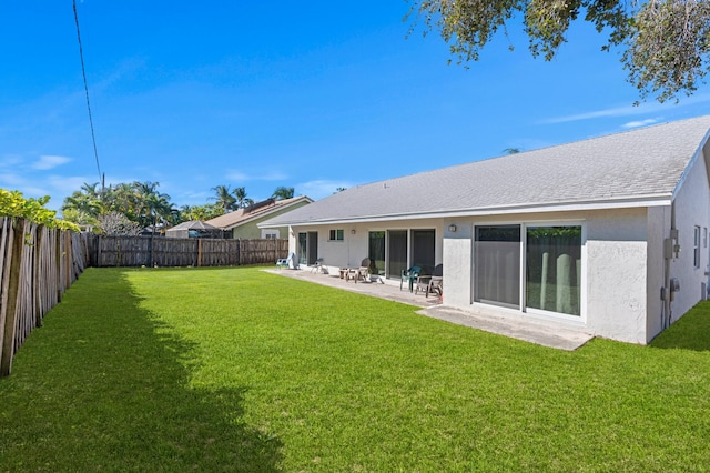 rear view of house with a lawn and a patio area