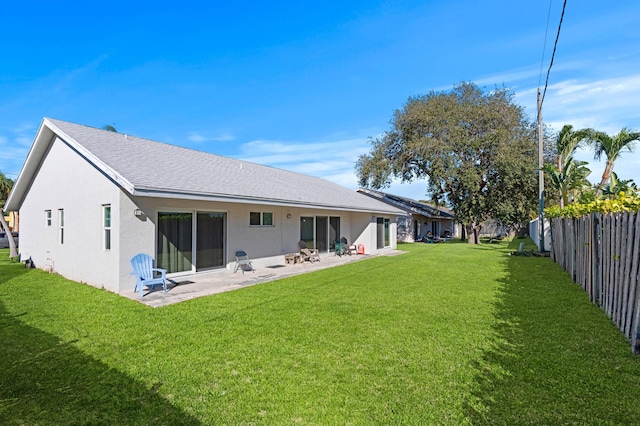 rear view of property with a patio and a lawn