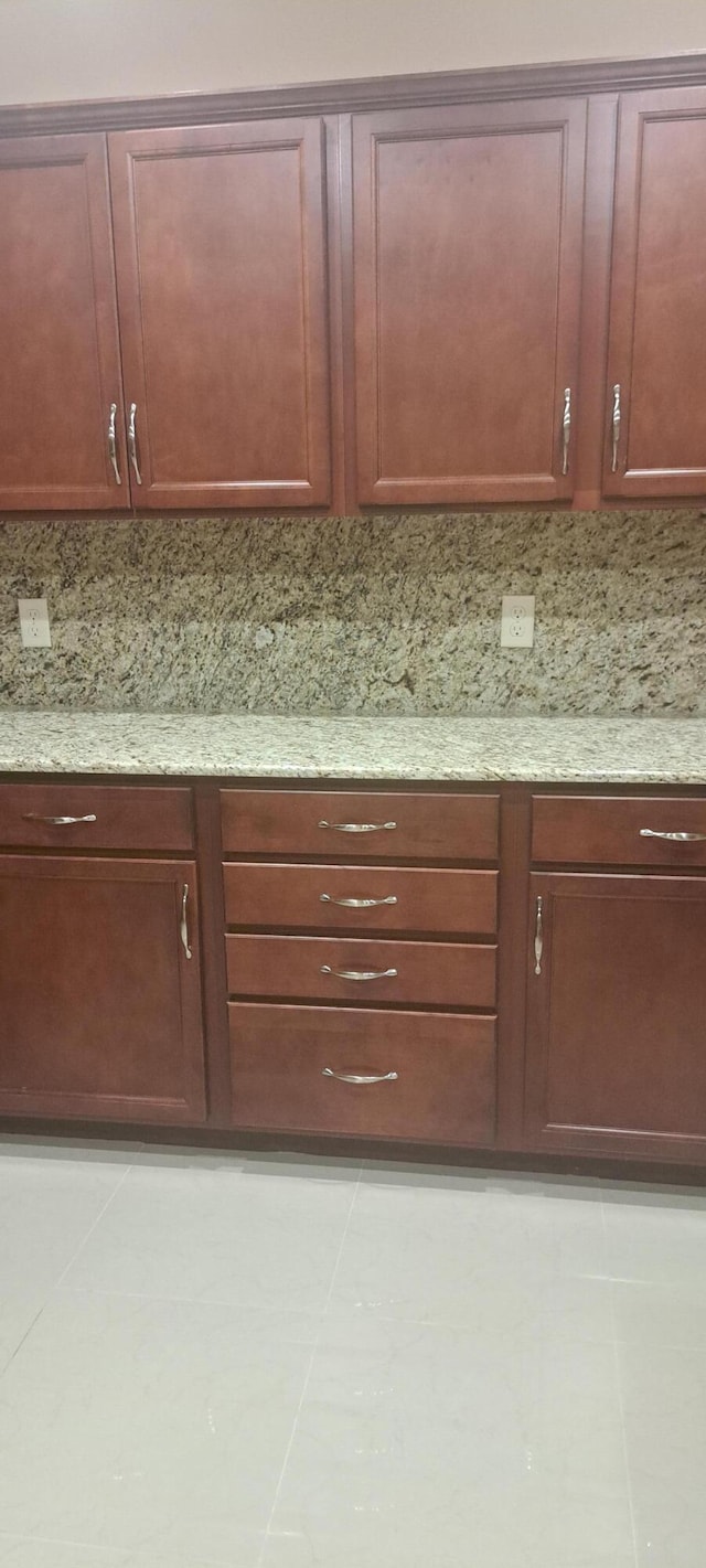 interior space with light stone countertops, light tile patterned floors, and backsplash