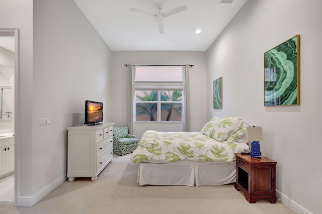 carpeted bedroom with ensuite bath and ceiling fan