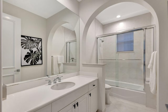 full bathroom featuring tile patterned floors, vanity, toilet, and bath / shower combo with glass door