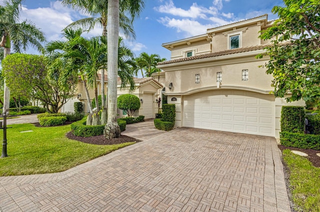 mediterranean / spanish house featuring a front yard and a garage