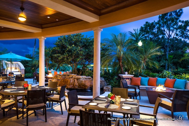 patio terrace at dusk featuring an outdoor living space with a fire pit