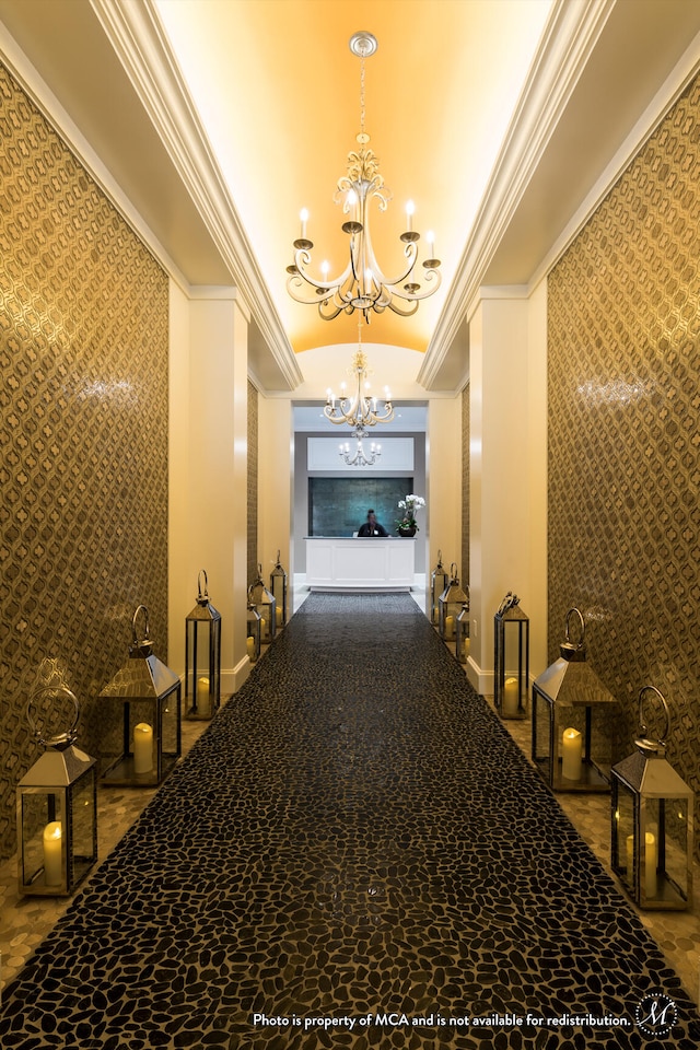 hallway with crown molding and a chandelier