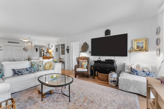 living room with a chandelier and light hardwood / wood-style flooring