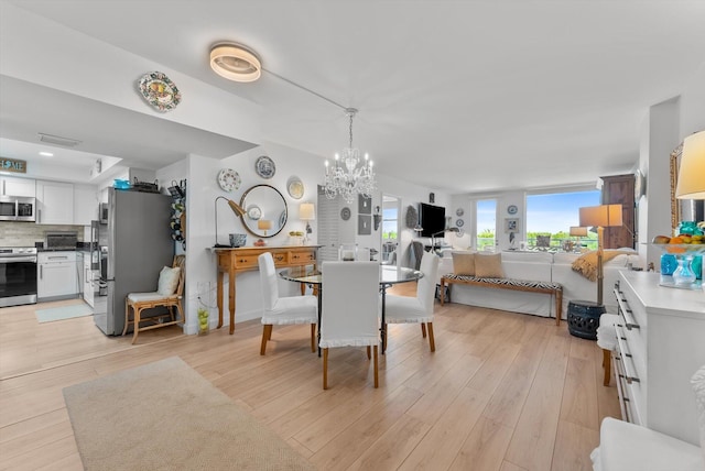 dining area featuring an inviting chandelier and light wood-type flooring