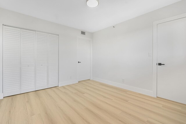 unfurnished bedroom featuring a closet and light hardwood / wood-style floors