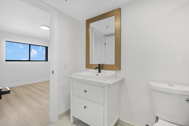 bathroom featuring hardwood / wood-style floors, vanity, and toilet