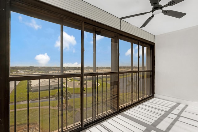 unfurnished sunroom featuring ceiling fan