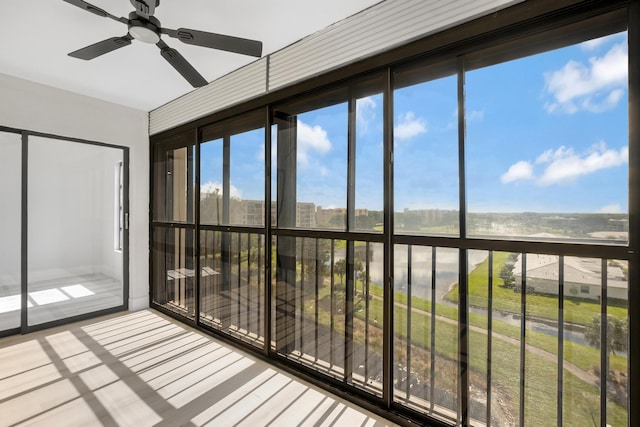 unfurnished sunroom with ceiling fan