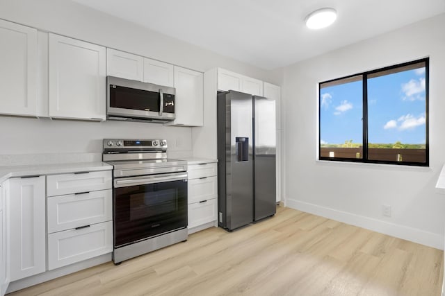 kitchen featuring white cabinetry, appliances with stainless steel finishes, and light hardwood / wood-style floors