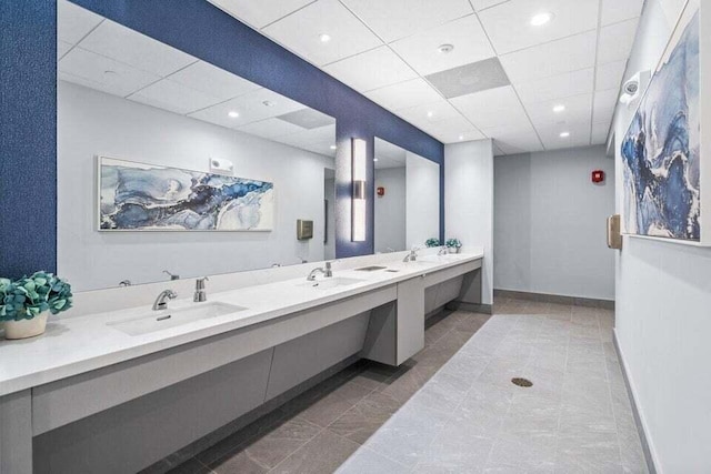 bathroom with a paneled ceiling, vanity, and tile patterned flooring