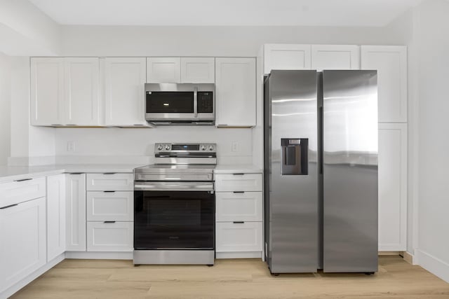 kitchen with white cabinetry, appliances with stainless steel finishes, and light wood-type flooring