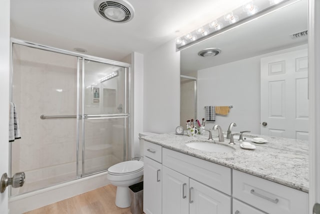 bathroom with vanity, a shower with shower door, wood-type flooring, and toilet