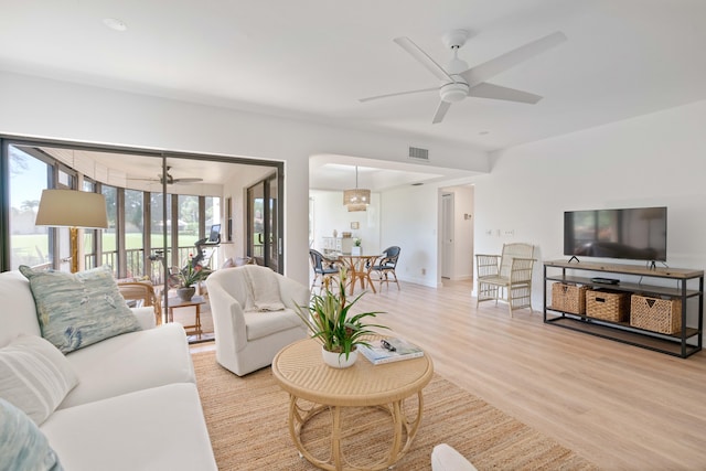 living room featuring light wood-type flooring, plenty of natural light, and ceiling fan