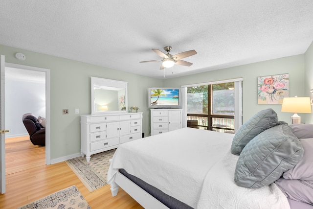 bedroom featuring light hardwood / wood-style floors, a textured ceiling, and ceiling fan