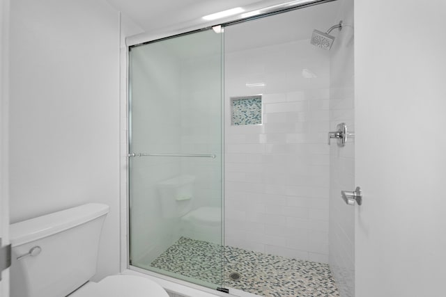 bathroom with toilet and an enclosed shower