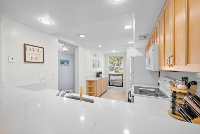 kitchen featuring white appliances, light brown cabinetry, sink, kitchen peninsula, and light stone counters