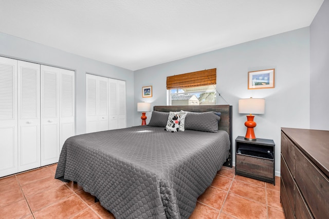 tiled bedroom featuring two closets