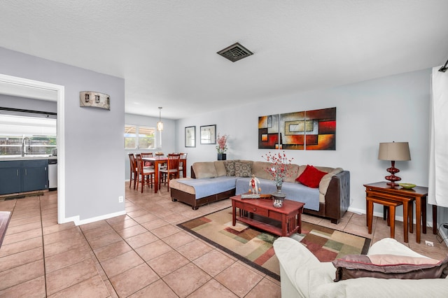 tiled living room with a textured ceiling and sink