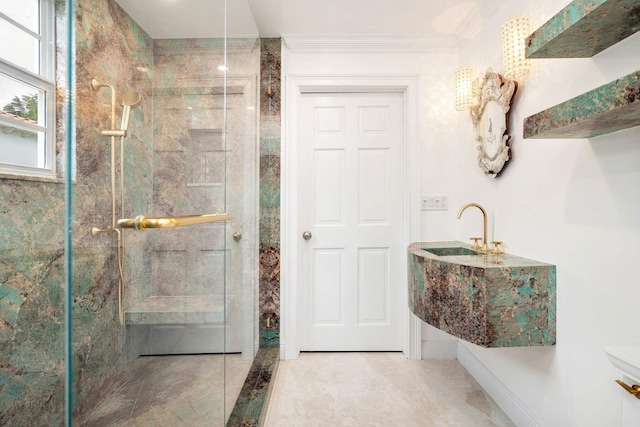 bathroom with tiled shower, crown molding, and sink