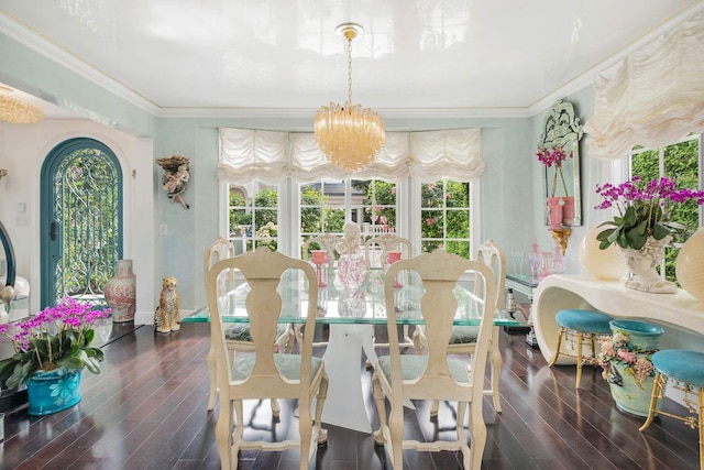 dining area with dark hardwood / wood-style flooring, ornamental molding, and an inviting chandelier