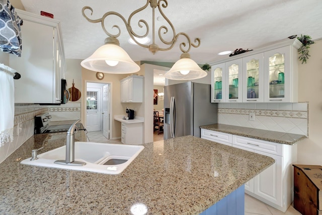 kitchen with decorative light fixtures, backsplash, sink, appliances with stainless steel finishes, and white cabinets