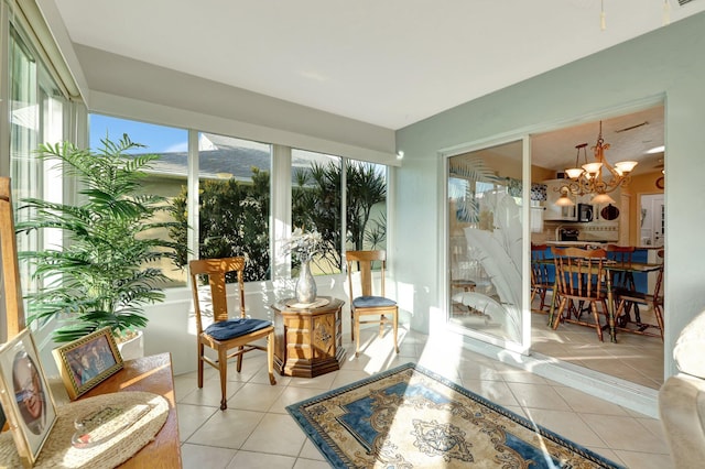 sunroom / solarium featuring a chandelier