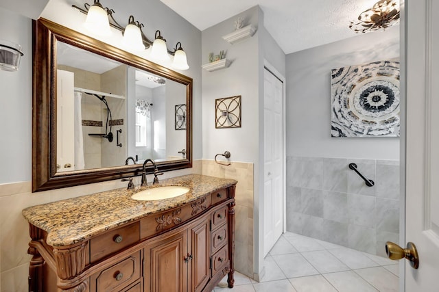 670 Senegal Ct, Fort Pierce, FL 34982 - bathroom featuring tile walls, a stall shower, wainscoting, vanity, and tile patterned floors