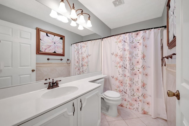 bathroom with toilet, vanity, tile patterned floors, and walk in shower