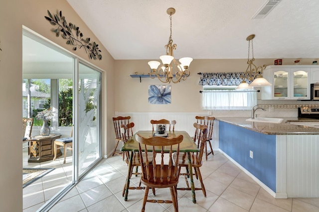 dining space with an inviting chandelier, light tile patterned floors, a healthy amount of sunlight, and sink