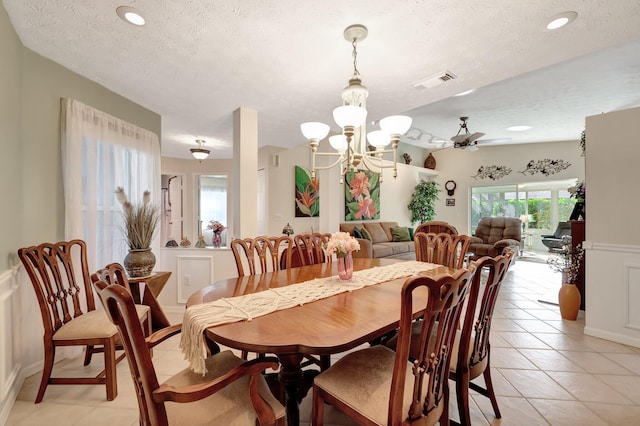 670 Senegal Ct, Fort Pierce, FL 34982 - dining room featuring a textured ceiling, light tile patterned floors, a chandelier, and a ceiling fan