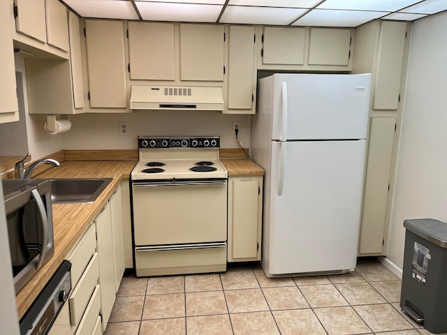 kitchen featuring light tile patterned flooring, white appliances, sink, and range hood