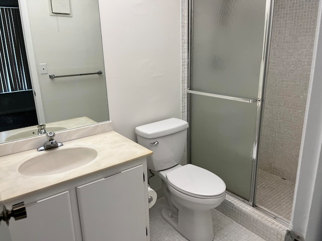 bathroom featuring toilet, vanity, tile patterned floors, and a shower with shower door