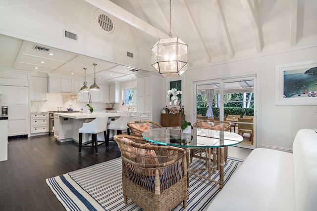 dining area with plenty of natural light, beamed ceiling, dark hardwood / wood-style floors, and a chandelier