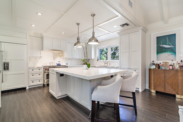 kitchen featuring white cabinets, high end range, pendant lighting, and a center island