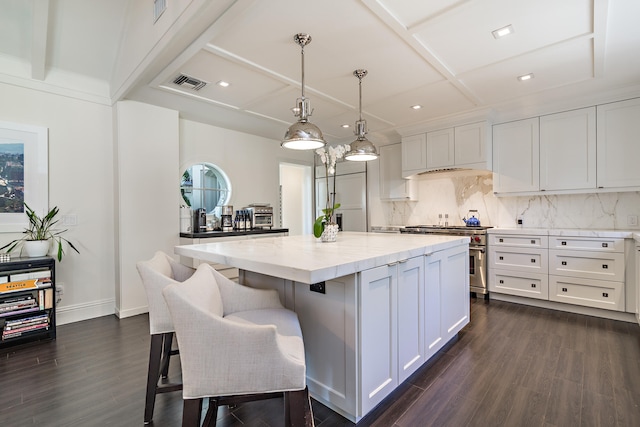 kitchen featuring white cabinetry, pendant lighting, high quality appliances, and a center island