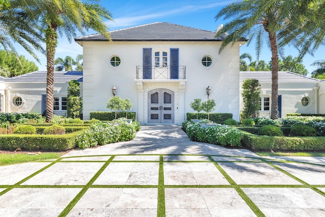 mediterranean / spanish house featuring french doors and a balcony